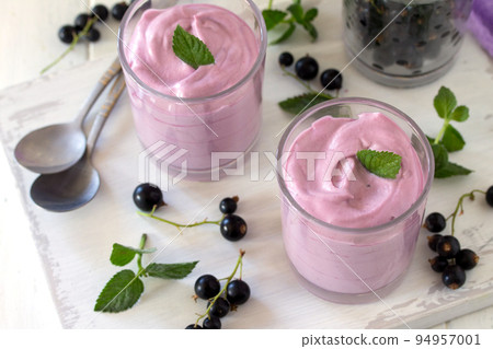 Homemade black currant mousse on wooden table. Homemade black currant mousse on wooden table. 94957001