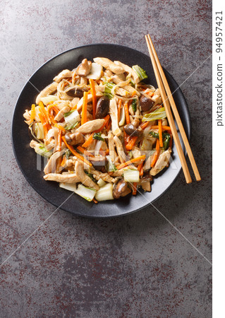 Chop Suey fried chicken with mushrooms, bok choy, onion, bean sprouts and carrots close-up in a plate. Vertical top view Chop Suey fried chicken with mushrooms, bok choy, onion, bean sprouts and carrots close-up in a plate. Vertical top view 94957421
