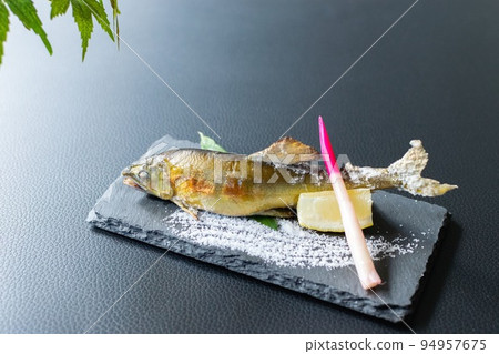 Salt-grilled sweetfish and wave salt drawn on a plate 94957675