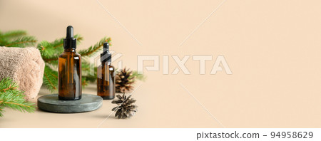 Christmas Spa wellness concept with cosmetic aroma oil, pine cones on beige background. 94958629