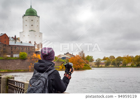 girl tourist in a hat and with a camera in his hands watching the sights of the city of Vyborg .Russia girl tourist in a hat and with a camera in his hands watching the sights of the city of Vyborg .Russia 94959119