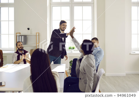 Colleagues giving high five greeting each other or express respect during business meeting in office Colleagues giving high five greeting each other or express respect during business meeting in office 94961049
