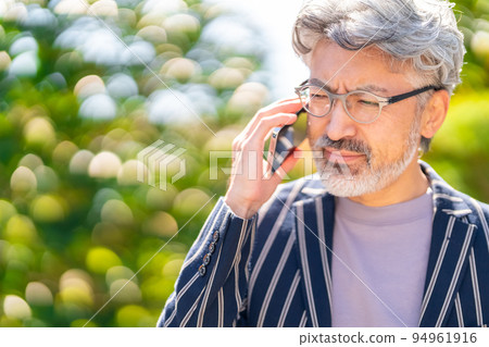 Cool businessman British gentleman elegant appearance cell phone smartphone green ball bokeh 94961916