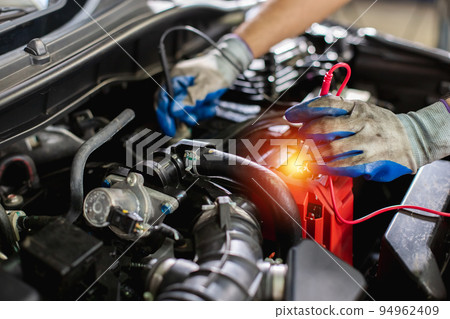 Transportation repair service concept, Repairman auto mechanic Checking battery power of car. Transportation repair service concept, Repairman auto mechanic Checking battery power of car. 94962409