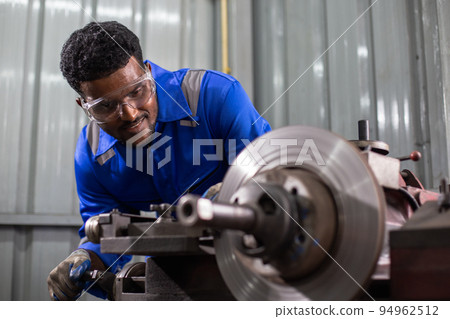 Engineering worker man African American wearing uniform safety working machine lathe metal. Engineering worker man African American wearing uniform safety working machine lathe metal. 94962512