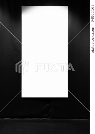 Blank vertical poster hangs on a black wall Blank vertical poster hangs on a black wall 94963162