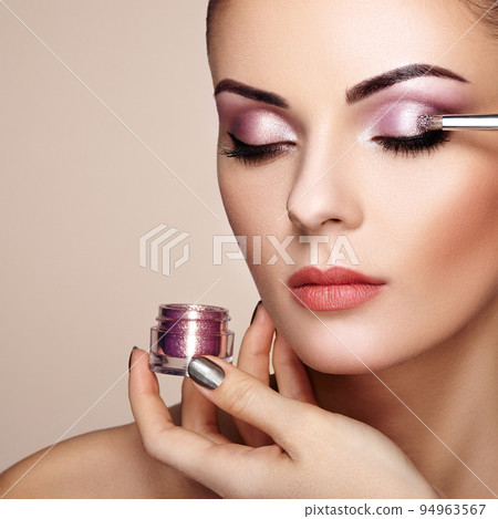 Makeup artist applies eye shadow 94963567