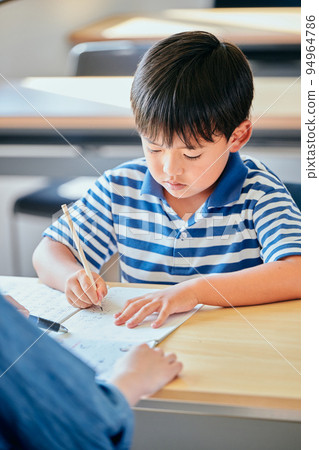 在筆記本上寫字的小學生 在筆記本上寫字的小學生 94964786