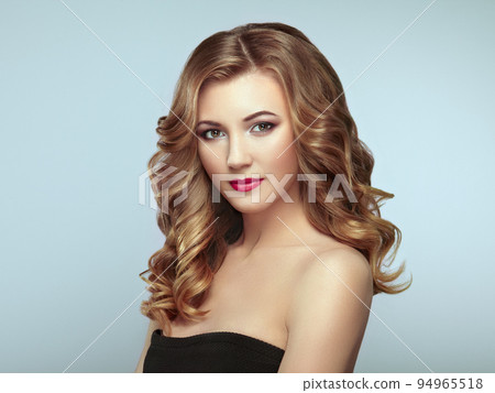 Blonde woman with long shiny wavy hair 94965518