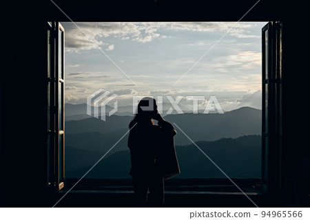 Rear view image of a female traveler looking at a beautiful mountain and 94965566