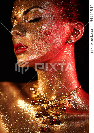 Portrait of beautiful woman with sparkles on her face 94965914