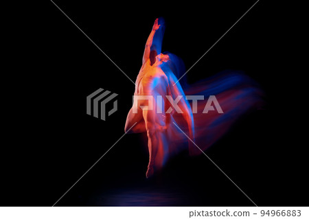 Young graceful and flexible shirtless male ballet dancer dancing isolated on dark background in glowing colorful neon light. Grace, art, beauty Young graceful and flexible shirtless male ballet dancer dancing isolated on dark background in glowing colorful neon light. Grace, art, beauty 94966883