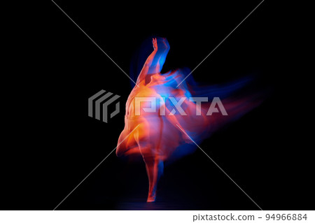 Like a phoenix. Solo performance of flexible adorable male ballet dancer isolated on dark background in glowing colorful neon light. Grace, art, beauty Like a phoenix. Solo performance of flexible adorable male ballet dancer isolated on dark background in glowing colorful neon light. Grace, art, beauty 94966884