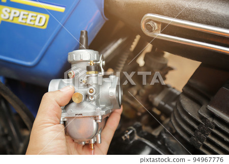 mechanic hand hold new carburetor for change in old car using for good running. motorcycle repairing concept idea. mechanic hand hold new carburetor for change in old car using for good running. motorcycle repairing concept idea. 94967776