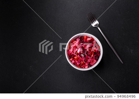 Traditional ukrainian beetroot salad vinaigrette on a white plate on a black concrete or slate background Traditional ukrainian beetroot salad vinaigrette on a white plate on a black concrete or slate background 94968496