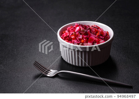 Traditional ukrainian beetroot salad vinaigrette on a white plate on a black concrete or slate background Traditional ukrainian beetroot salad vinaigrette on a white plate on a black concrete or slate background 94968497