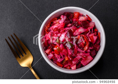 Traditional ukrainian beetroot salad vinaigrette on a white plate on a black concrete or slate background 94968498