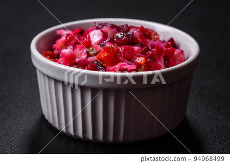 Traditional ukrainian beetroot salad vinaigrette on a white plate on a black concrete or slate background Traditional ukrainian beetroot salad vinaigrette on a white plate on a black concrete or slate background 94968499
