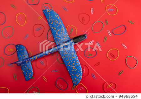 Toys and aircraft. Blue plane on a red background. Airplane and patterns. 94968654