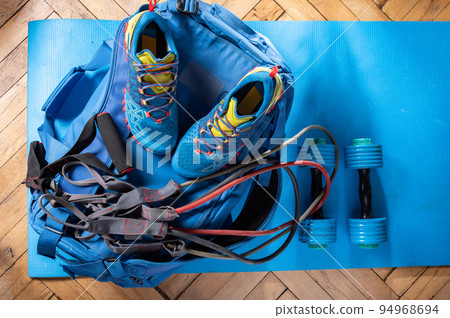 Blue sports equipment. Cardio and fitness stuff. Blue clothes on a blue fitness mat. Dumbbells for rubber expander. Blue sports equipment. Cardio and fitness stuff. Blue clothes on a blue fitness mat. Dumbbells for rubber expander. 94968694