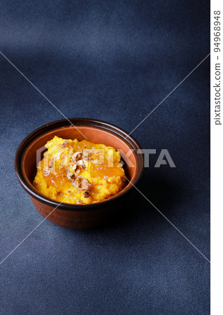 Sweet pumpkin porridge in clay bowl with jam and nuts Sweet pumpkin porridge in clay bowl with jam and nuts 94968948