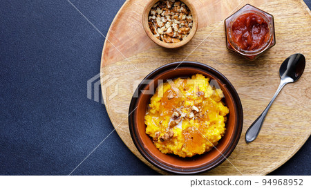 Sweet pumpkin porridge in clay bowl with jam and nuts Sweet pumpkin porridge in clay bowl with jam and nuts 94968952