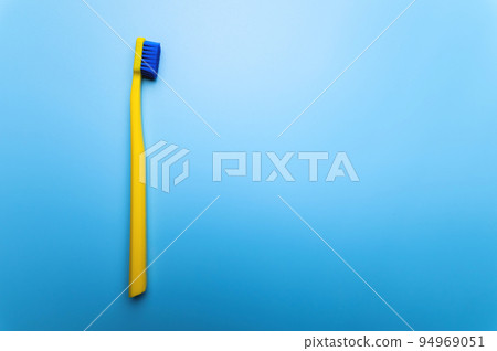 top view close-up of a bright toothbrush, alone, without people, lies on a blue background top view close-up of a bright toothbrush, alone, without people, lies on a blue background 94969051