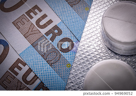This macro image is for a twenty euro banknote. It shows pills in a blister over, with a blue color background. EU economics and healthcare This macro image is for a twenty euro banknote. It shows pills in a blister over, with a blue color background. EU economics and healthcare 94969052