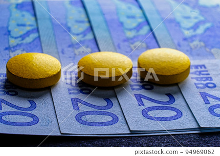 Expensive medicine treatment, tablets pills on 20 euro bills fan, macro image 94969062