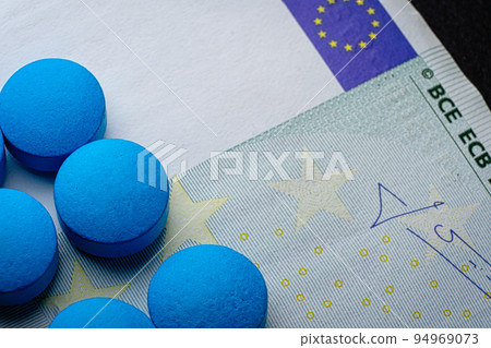 Blue tablets pill macro on euro bill. Drug abuse. Copyspace 94969073