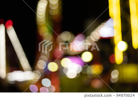 blurred bokeh silhouette of illuminated fun park 94970024