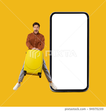 Excited Traveler Guy Jumping Near Large Cellphone On Yellow Background Excited Traveler Guy Jumping Near Large Cellphone On Yellow Background 94970289