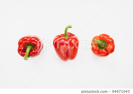 Three fresh ripe sweet red bell peppers on white background. Healthy vegan food and ingredients for cooking concept. Top view, copy space 94971045