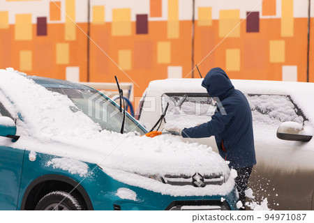 Cleaning the car after a snowfall Cleaning the car after a snowfall 94971087