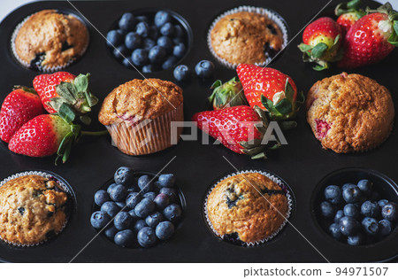 Blueberry and strawberry muffins with berries. Close up. Top view. 94971507