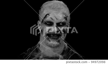 Devil scary man with Halloween zombie bloody wounded makeup, showing tongue, trying to scare Devil scary man with Halloween zombie bloody wounded makeup, showing tongue, trying to scare 94972098