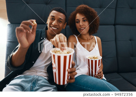 Couple watching movie with popcorn in cinema. Couple watching movie with popcorn in cinema. 94972356