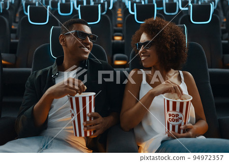 Couple watching movie with popcorn in cinema. Couple watching movie with popcorn in cinema. 94972357