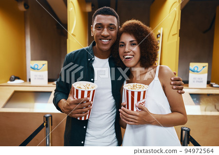 A man and a woman came to the cinema. People in 3D glasses and with popcorn are ready for a movie. A man and a woman came to the cinema. People in 3D glasses and with popcorn are ready for a movie. 94972564