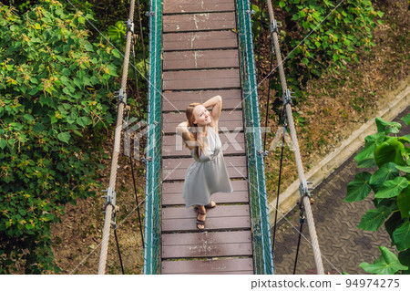 Young woman at the Suspension bridge in Kuala Lumpur, Malaysia 94974275