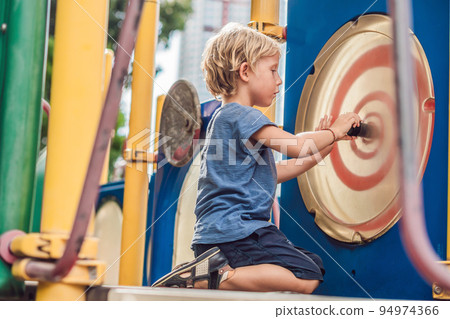 Funny cute happy baby playing on the playground. The emotion of happiness, fun, joy Funny cute happy baby playing on the playground. The emotion of happiness, fun, joy 94974366