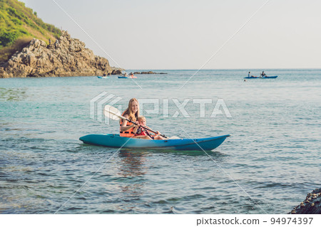 Mother and son kayaking at tropical ocean. Mother and son kayaking at tropical ocean. 94974397
