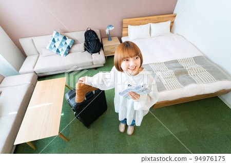 Woman overlooking hotel room 94976175
