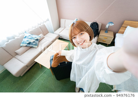 Woman overlooking hotel room 94976176