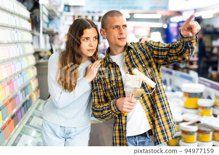 Woman and man points his hand at something in hardware store 94977159