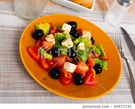 Avocado salad with tomatoes, olives and feta cheese 94977242