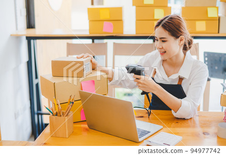 Small business owners online are scanning barcode-labelled parcel boxes with a barcode scanner to verify their product orders. of online retailers - online shopping 94977742