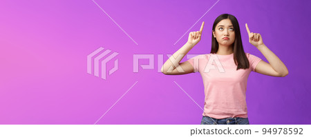 Sad disappointed sulking asian girl with short dark haircut, look pointing up upset, feel jealous, regret, missing good opportunity, staring unhappy top advertisement, stand purple background Sad disappointed sulking asian girl with short dark haircut, look pointing up upset, feel jealous, regret, missing good opportunity, staring unhappy top advertisement, stand purple background 94978592