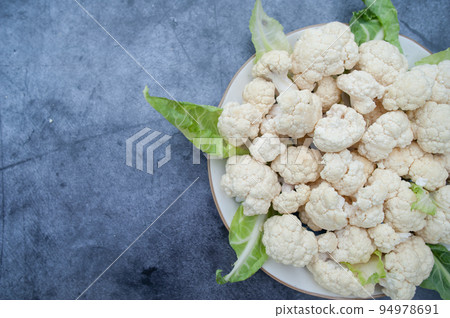 Cauliflower inflorescences close-up on a plate, top view, space for text Cauliflower inflorescences close-up on a plate, top view, space for text 94978691