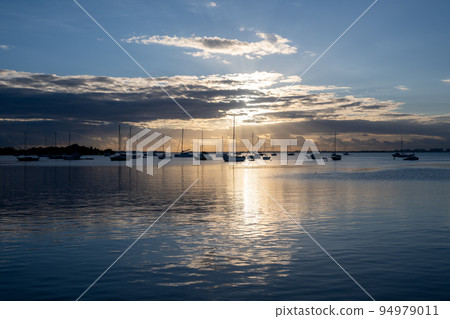Sailboats in Dinner Key anchorage reflected in calm water of Biscayne Bay. 94979011